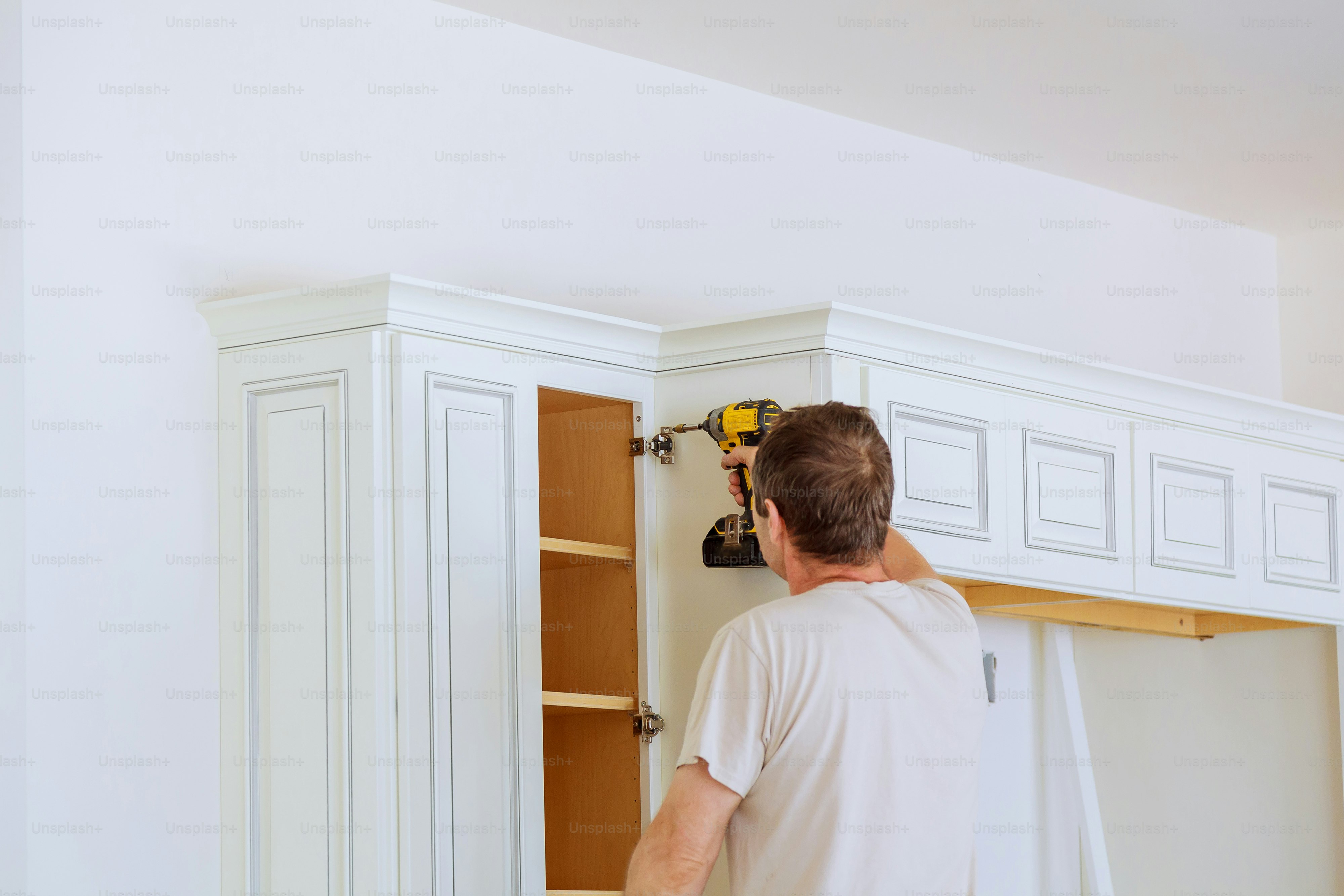 technician man installing kitchen cabinets Installation of kitchen cabinet.